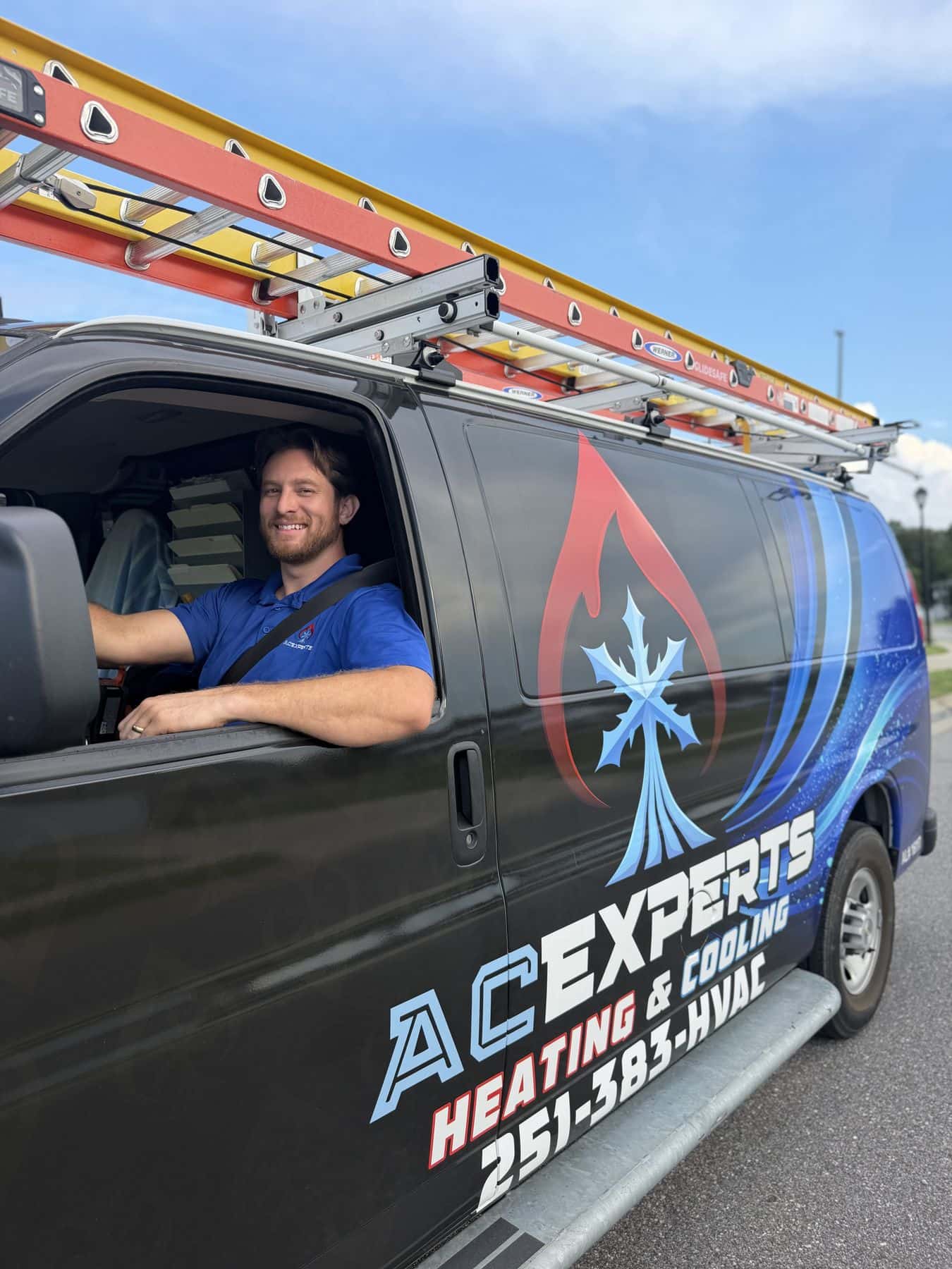 Landon Jahnke, founder of ACExperts, at the wheel of a wrapped ACExperts service van