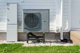 Heat pump unit installed on a home exterior with gravel base