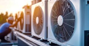 Rooftop HVAC condensers with technician working in background